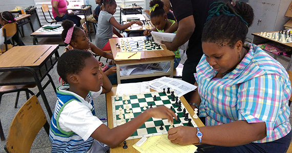 A mother plays a game of chess with her son.